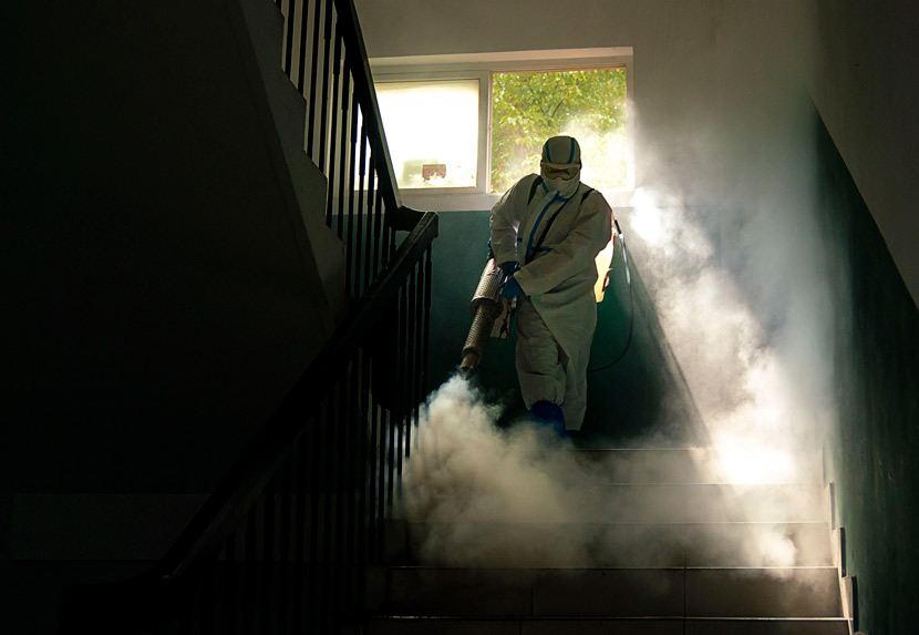 A medical worker sprays disinfectant in a stairwell of a building in Wuhan, Hubei province, March 10, 2020. Xiong Qi/Xinhua