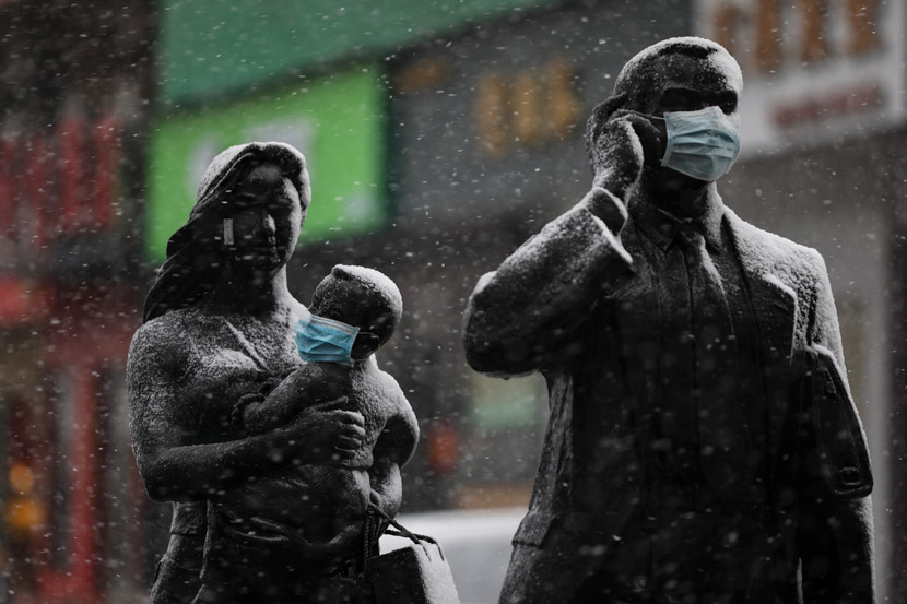 A mask placed over a child statue’s face on a snowy day in Wuhan, Hubei province, Feb. 15, 2020. Yuan Zheng/Changjiang Daily