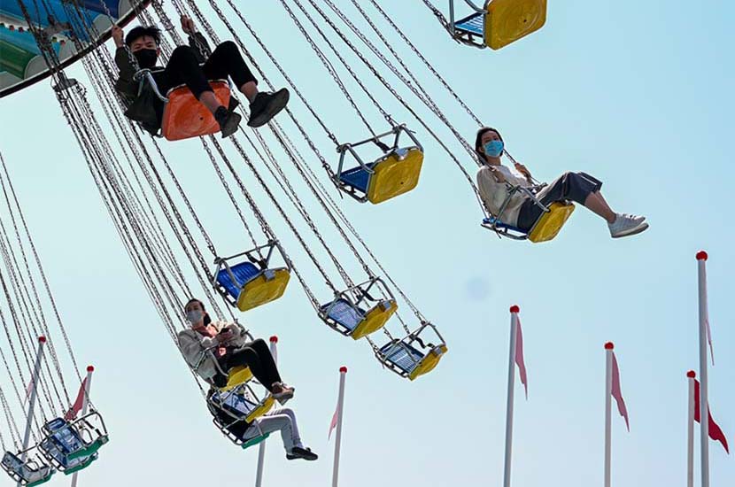 After a process of booking tickets online, tourists enjoy a ride at the Happy Valley amusement park in Shanghai, March 20, 2020. Zhu Weihui for Sixth Tone