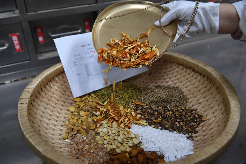 A pharmacist checks the materials for the “lung-cleansing decoction” at the pharmacy in Anhui Province Hospital of Traditional Chinese Medicine in Hefei, Anhui province, Feb. 21, 2020. Zhang Dagang via Xinhua