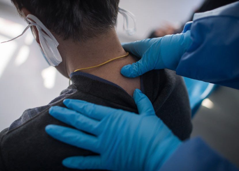 A medical worker gives a COVID-19 patient a therapeutic massage at a hospital in Wuhan, Hubei province, March 19, 2020. Xiao Yijiu/Xinhua