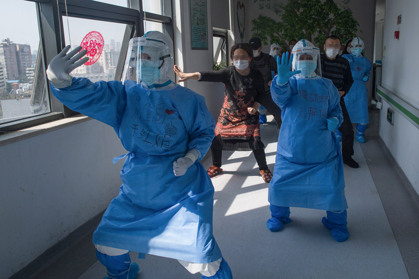 Medical workers lead patients in a session of “Baduanjin,” one of the most common forms of meditative exercise qi gong, in the corridor of a hospital in Wuhan, Hubei province, March 19, 2020. Xiao Yijiu/Xinhua