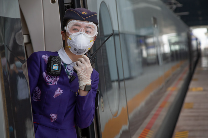 An attendant on a high-speed train at a railway station in Xiangyang, Hubei province, March 25, 2020. Yang Dong via Xinhua