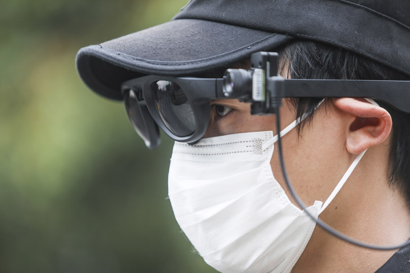 A security guard dons AI-powered sunglasses with built-in infrared cameras to measure visitors’ body temperatures at a park in Hangzhou, Zhejiang province, March 24, 2020. Ma Chongyan/Rayfoto/IC