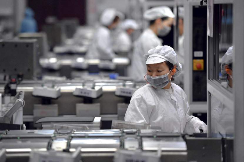 Workers at a production line at a photovoltaic company in Luoyang, Henan province, March 5, 2020. Li Jianan/Xinhua