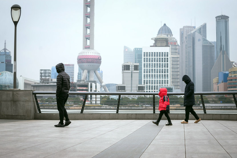 A family walks along the Bund in Shanghai, March 11, 2020. Lü Wei/IC