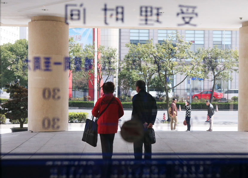 A couple walks out of the marriage registration office after finishing their divorce process in Shanghai, March 8, 2013. Zhang Xinyan for Sixth Tone