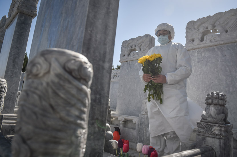A worker at a public cemetery sweeps gravesites for people could not come themselves, Beijing, March 28, 2020. Peng Ziyang/Xinhua