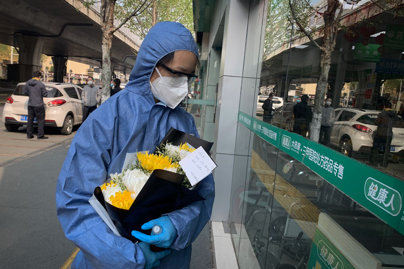 A 24-year-old Wuhan resident leaves flowers outside of Central Hospital in Wuhan, Hubei province, April 4, 2020. Ye Ruolin/Sixth Tone