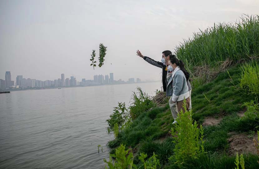 A couple honors Tomb-Sweeping Day in Wuhan, Hubei province, April 4, 2020. This year’s holiday was named a national day of mourning for victims of the ongoing COVID-19 pandemic. Sun Zhan for Sixth Tone