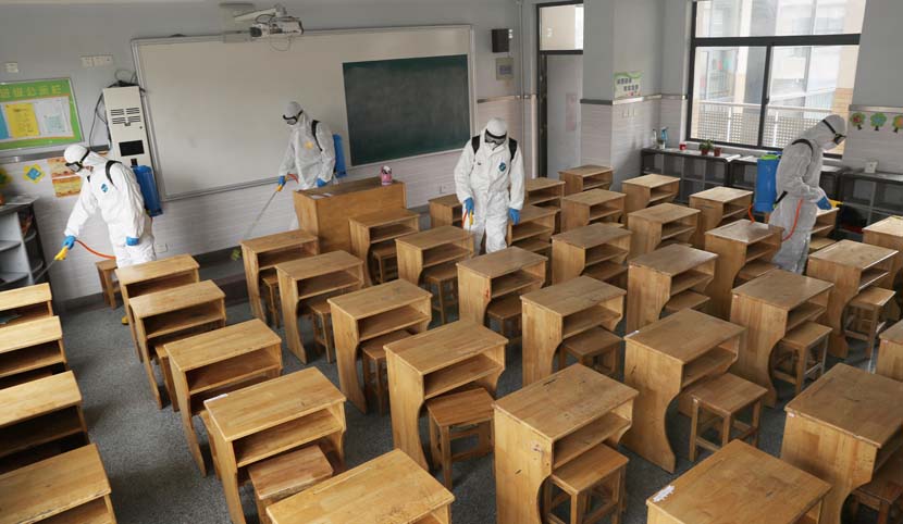Firefighters disinfect an elementary school in Nantong, Jiangsu province, March 30, 2020.