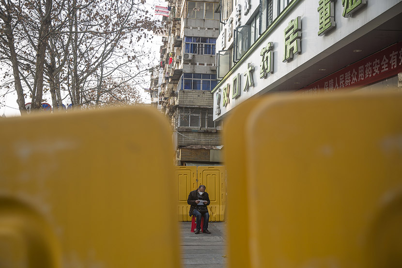 A senior waits outside a pharmacy in Wuhan, Hubei province, Feb. 23, 2020. Residents with special needs received gate passes that allowed them to go out and buy medicine at designated pharmacies. Gerry Yin/Wild Photos