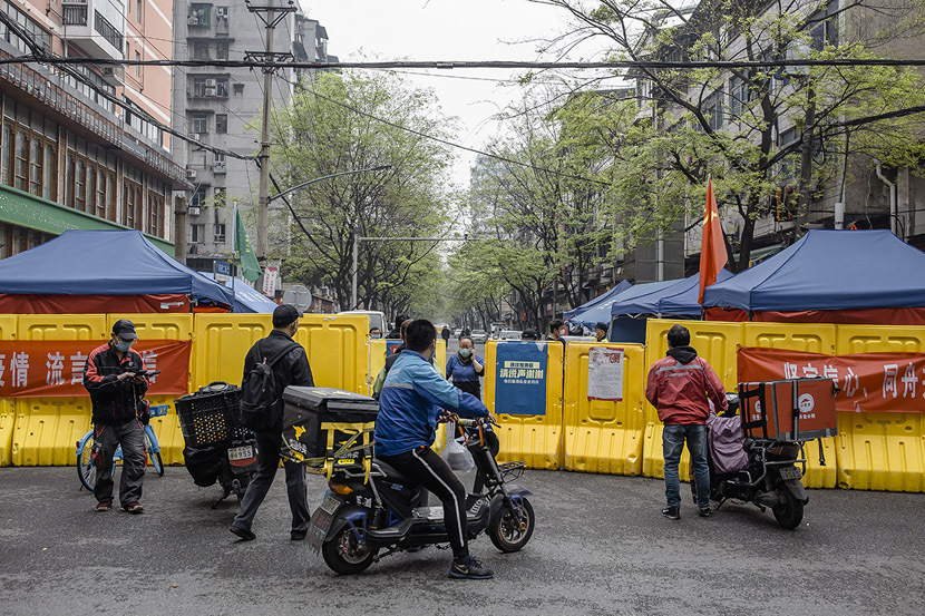 Delivery drivers wait for residents to pick up their orders outside a community in Wuhan, Hubei province, March 22, 2020. Drivers were not allowed to enter residential compounds during the lockdown. Gerry Yin/Wild Photos