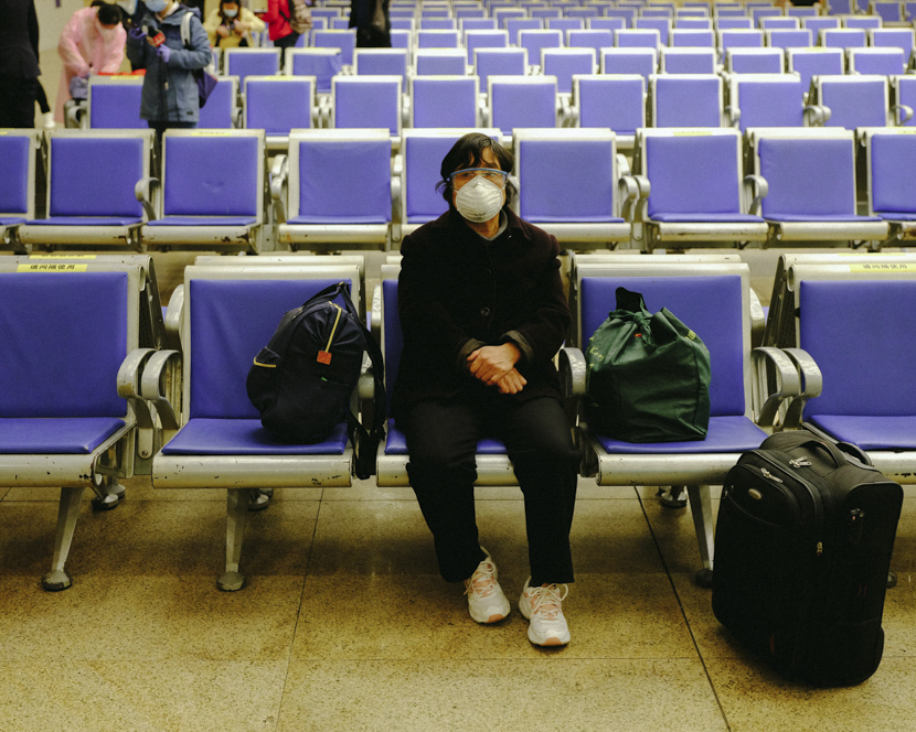 A woman waits for her early-morning train at Hankou Railway Station in Wuhan, Hubei province, April 8, 2020. Hers is the first train departing from the station. Shi Yangkun/Sixth Tone