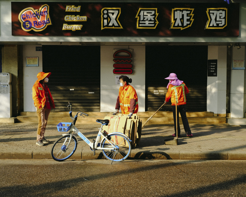 Sanitation workers chat on the street in Wuhan, Hubei province, April 8, 2020. Shi Yangkun/Sixth Tone