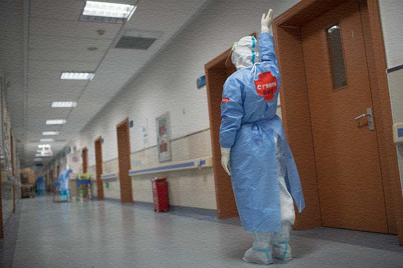 A member of the Guangdong medical support team waves farewell to a Wuhan staff member, March 19, 2020. Southern Visual/People Visual