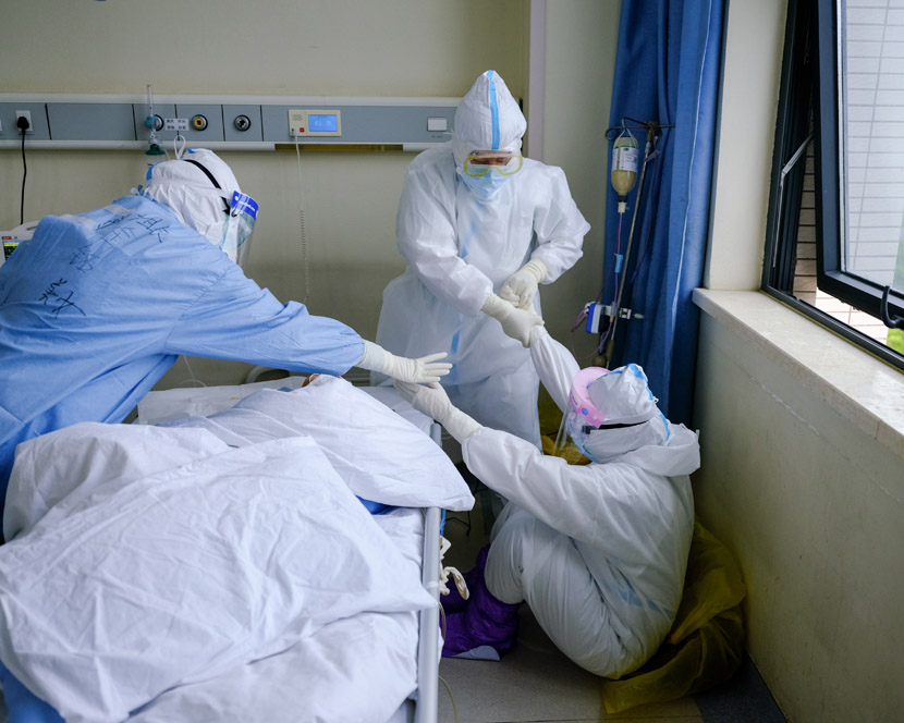 A medical worker falls down because of their legs going numb after a prolonged period working in a protective suit at a ward in the Wuhan Union Hospital (West Branch) in Wuhan, Hubei province, April 11, 2020. Shi Yangkun/Sixth Tone