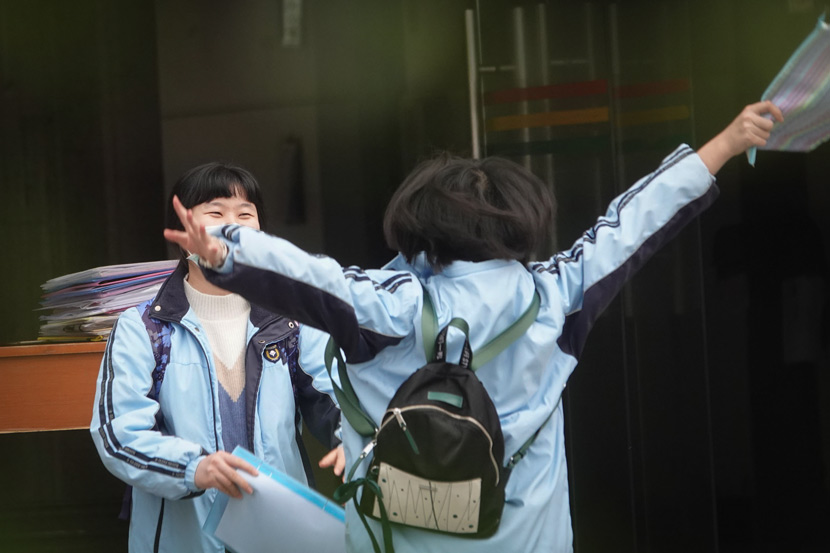 A student hugs her friend from a distance during an open day of the spring semester at a middle school in Nanning, Guangxi Zhuang Autonomous Region, April 7, 2020. Yu Xiangquan/People Visual