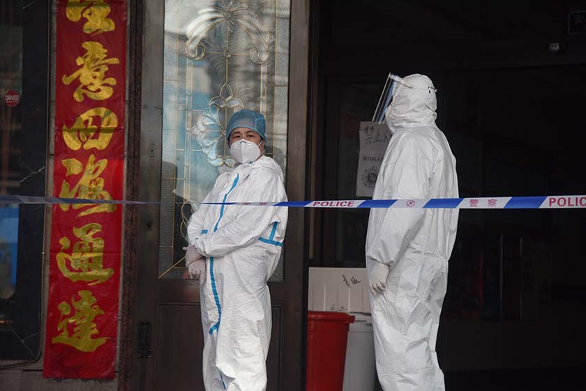 Medical workers in protective gear stand at the entrance to a quarantine hotel in Suifenhe, Heilongjiang province, April 10, 2020. Xinhua