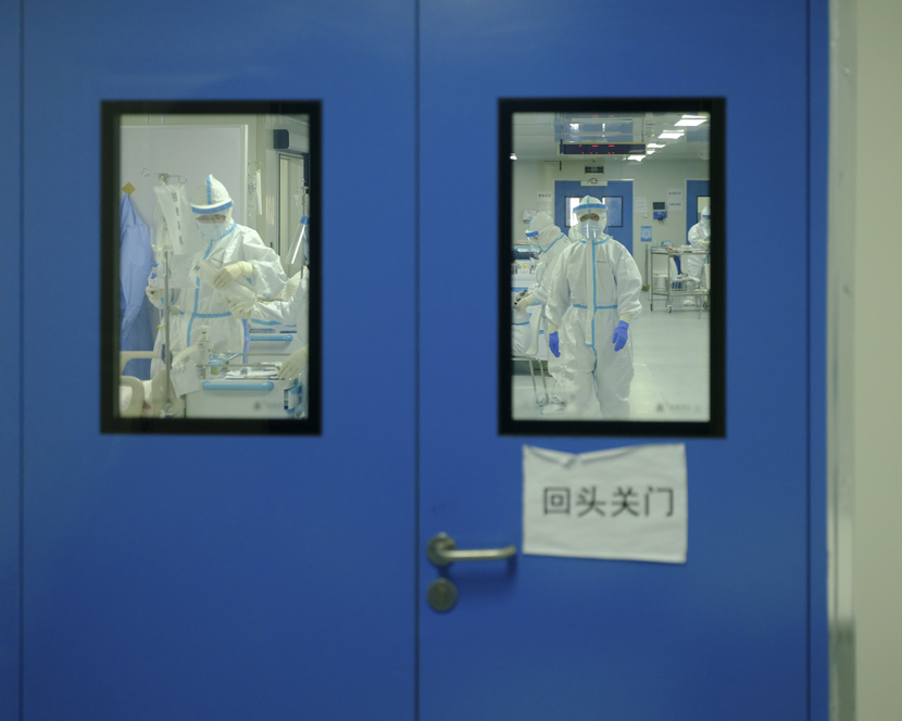 Medical workers are seen through a door inside Leishenshan Hospital in Wuhan, Hubei province, April 10, 2020. Shi Yangkun/Sixth Tone