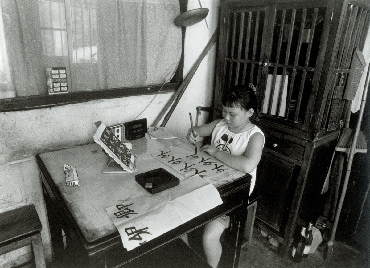 A girl practices calligraphy at home on Dongchang Road, Shanghai, 1999. Courtesy of Wu Jianping