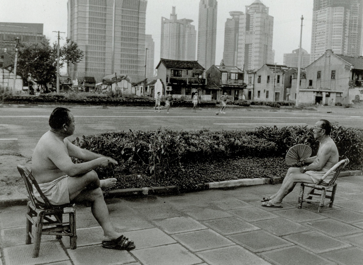 Two men watch a soccer match on South Yincheng Road, Shanghai, 1998. Courtesy of Wu Jianping