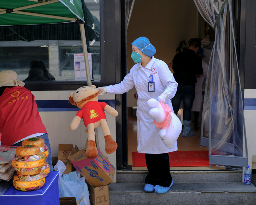 A nurse holds toys to be given to donors at a blood donation point in Wuhan, Hubei province, April 9, 2020. Shi Yangkun/Sixth Tone