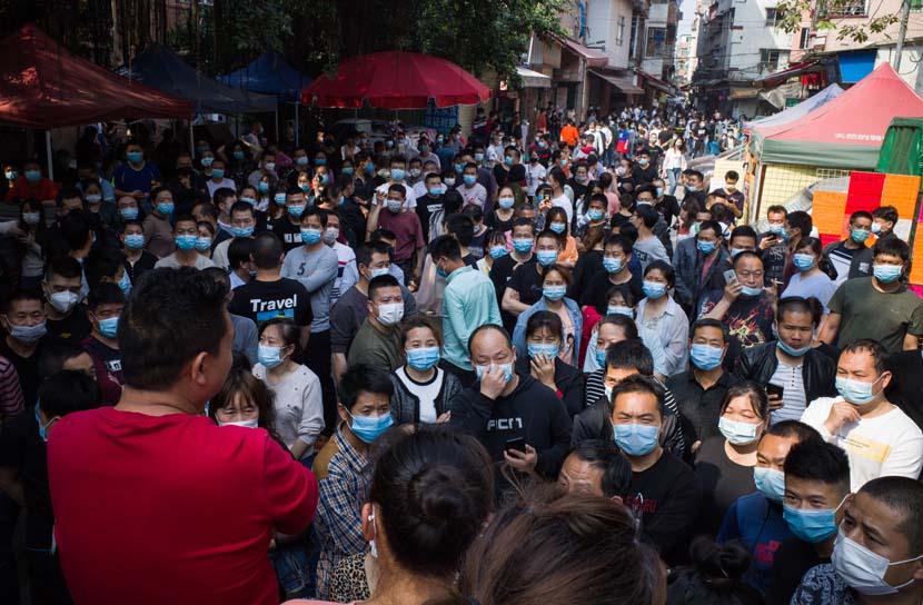 Migrant workers and clothing workshop owners gather at a street corner in Datang Village in Guangzhou, Guangdong province, April 15, 2020. Chen Xiao for Sixth Tone