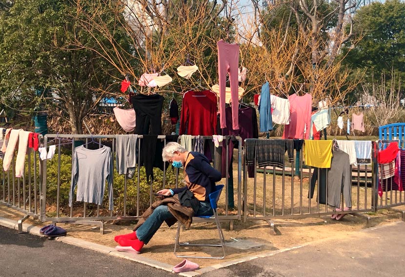 A patient enjoys the sunshine outside the stadium shelter hospital in Wuhan, Hubei province, February 2020. Yi Bei for Sixth Tone