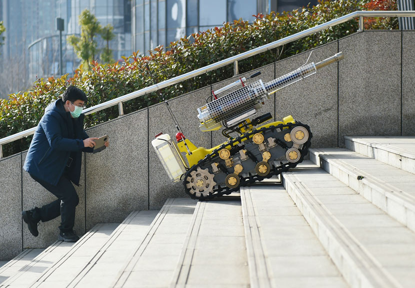 A robot capable of spraying disinfectant climbs up steps in Luoyang, Henan province, Feb. 22, 2020. Huang Zhengwei/People Visual