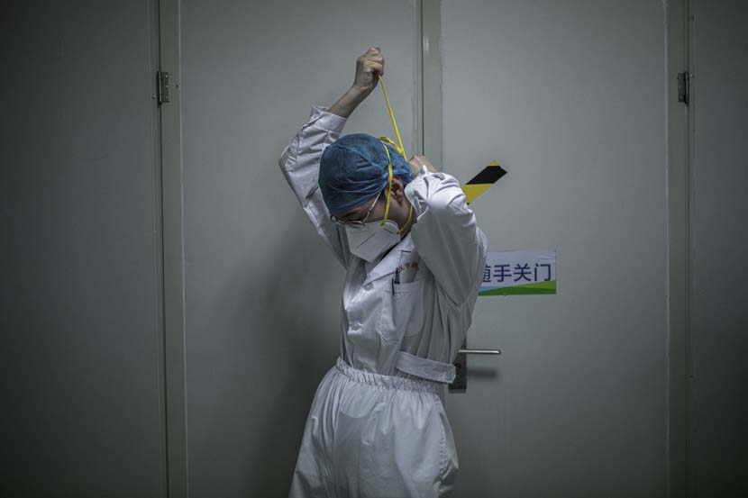 A medical worker gets equipped before entering the Wuhan Pulmonary Hospital ICU, Hubei province, March 13, 2020. Sun Zhan for Sixth Tone