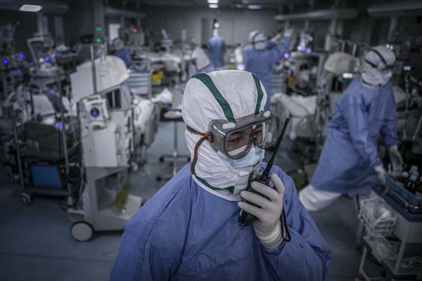 A medical worker communicates with his colleague through a walkie-talkie in the Wuhan Pulmonary Hospital ICU, Hubei province, March 14, 2020. Sun Zhan for Sixth Tone