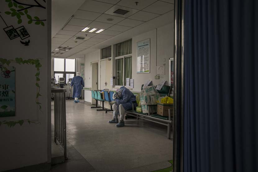 A medical worker takes a break after transferring a patient in Wuhan Pulmonary Hospital, Hubei province, March 31, 2020. Sun Zhan for Sixth Tone
