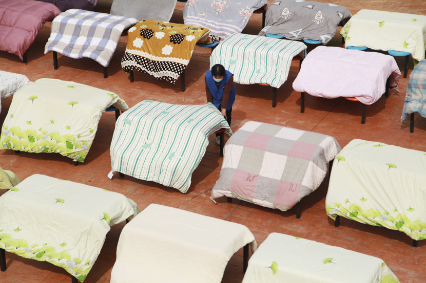 A dormitory keeper airs the quilts of students who are still waiting to return for the new semester at a university in Hangzhou, Zhejiang province, April 22, 2020. Chen Shengwei/People Visual