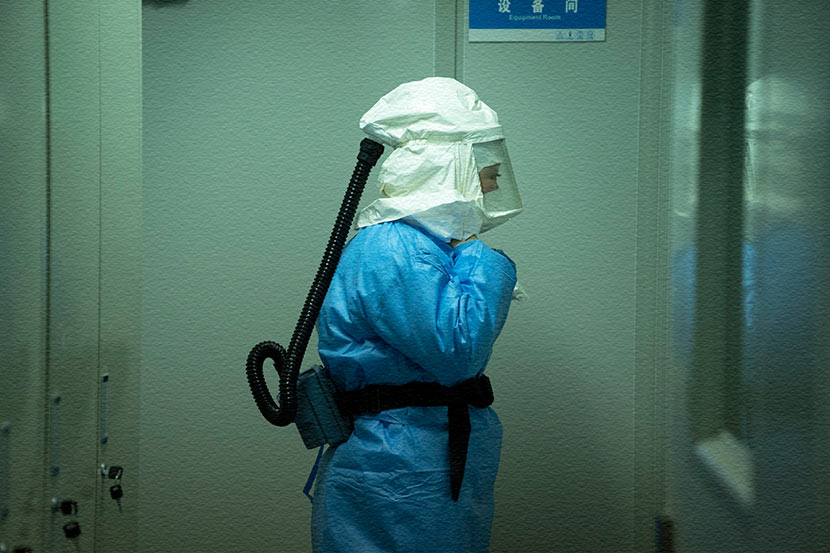 A medical worker prepares to enter a laboratory for nucleic acid testing in Enshi, Hubei province, Feb. 8, 2020. Xie Chuanhui/People Visual