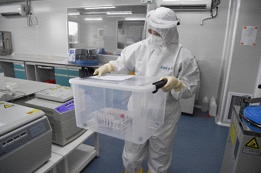 A lab technician transports samples for nucleic acid tests at an independent clinical laboratory in Beijing, April 18, 2020. Hou Yu/CNS/People Visual
