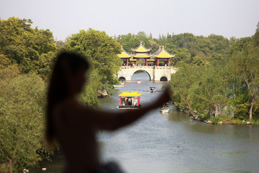 A tourist poses for a selfie near the Slender West Lake in Yangzhou, Jiangsu province, April 25, 2020. Meng Delong/People Visual