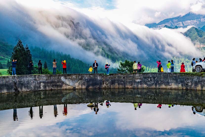 Tourists take photos of the mountainous scenery in Chongqing, May 1, 2020. People Visual
