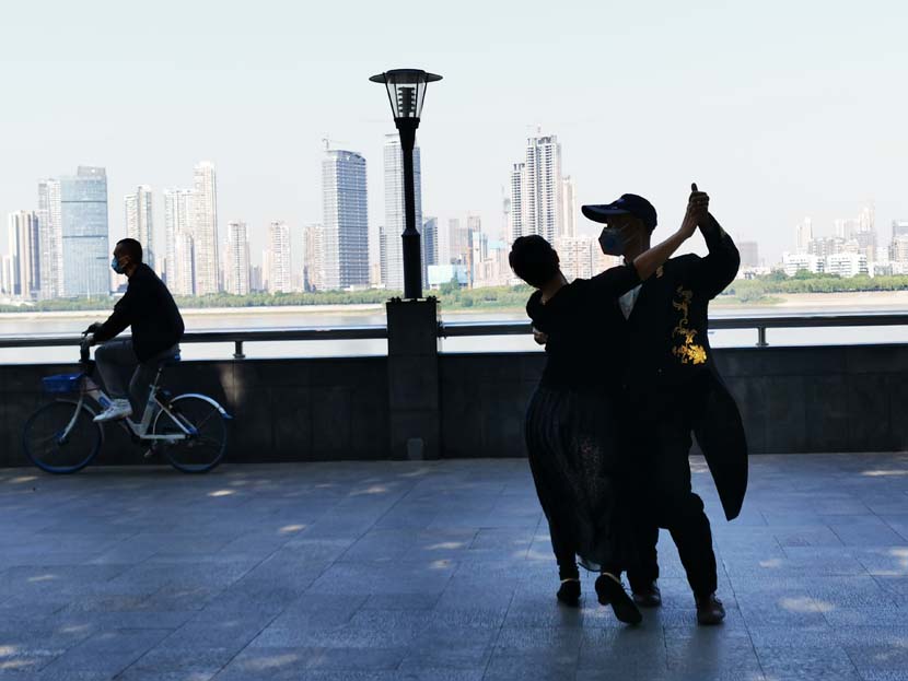 A couple dances alongside the Wuhan Yangtze River Bridge in Wuhan, Hubei province, April 27, 2020. People Visual