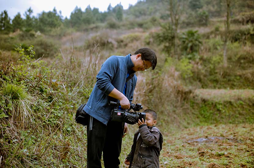 Jiang Nengjie communicates with a child during one of his reporting trips. Courtesy of Jiang