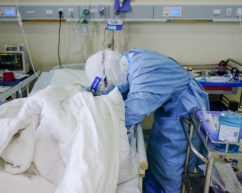A medical worker checks a patient’s condition at Wuhan Union Hospital (West Branch) in Wuhan, Hubei province, April 11, 2020. Shi Yangkun/Sixth Tone