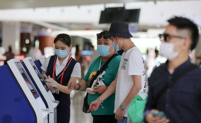 Passengers check in at an airport in Haikou, Hainan province, May 1, 2020. People Visual