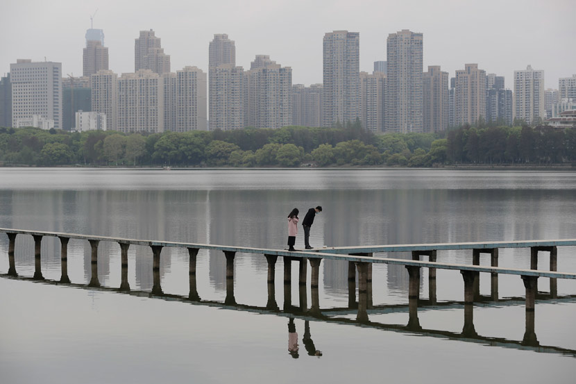 A couple walks by the East lake, which is near Wuhan University, March 30, 2020. People Visual