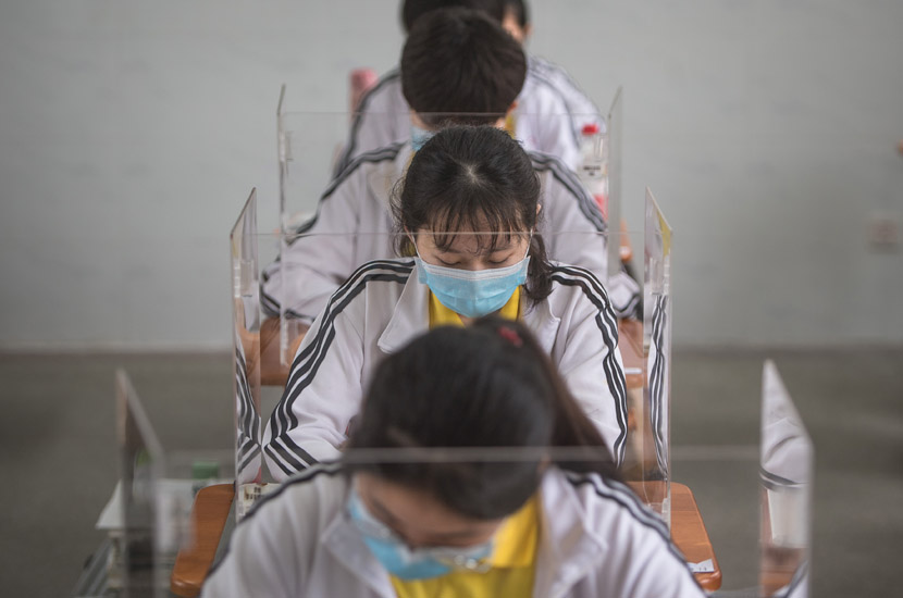 High school students study at their desks in Wuhan, Hubei province, May 6, 2020. The plastic barriers are intended to reduce the risk of coronavirus transmission. Xiao Yijiu/Xinhua