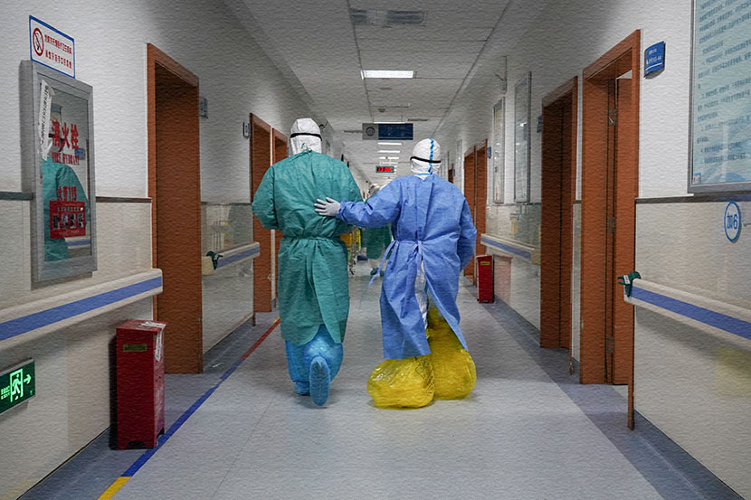 Author Wu Feng (right) and another doctor, Wang Kai, in the corridor of Hankou Hospital in Wuhan, Hubei province, Feb. 11, 2020. Wu is wearing yellow trash bags over her shoes due to continued shortages of protective supplies. Courtesy of Wu Feng
