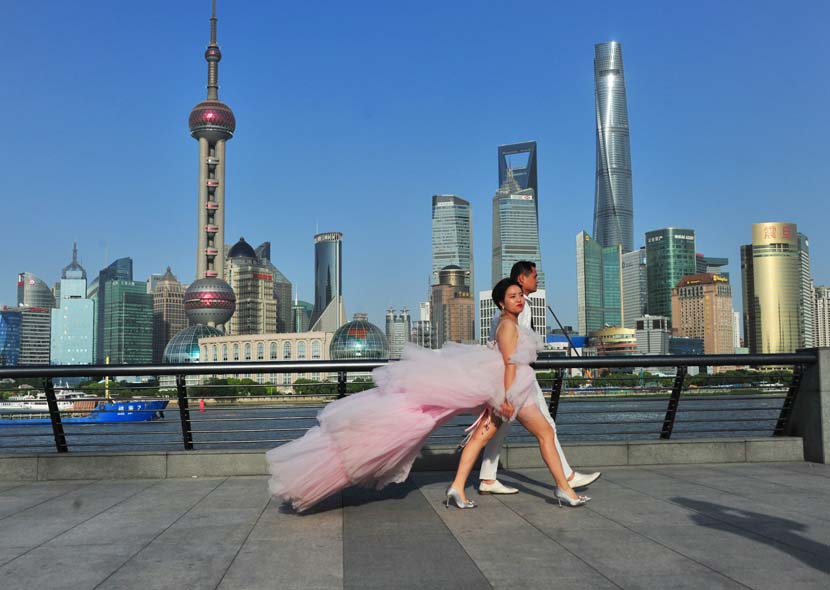 A couple takes part in a wedding photo shoot on a hot early summer day at the Bund in Shanghai, May 13, 2020. Zhong Yang/IC