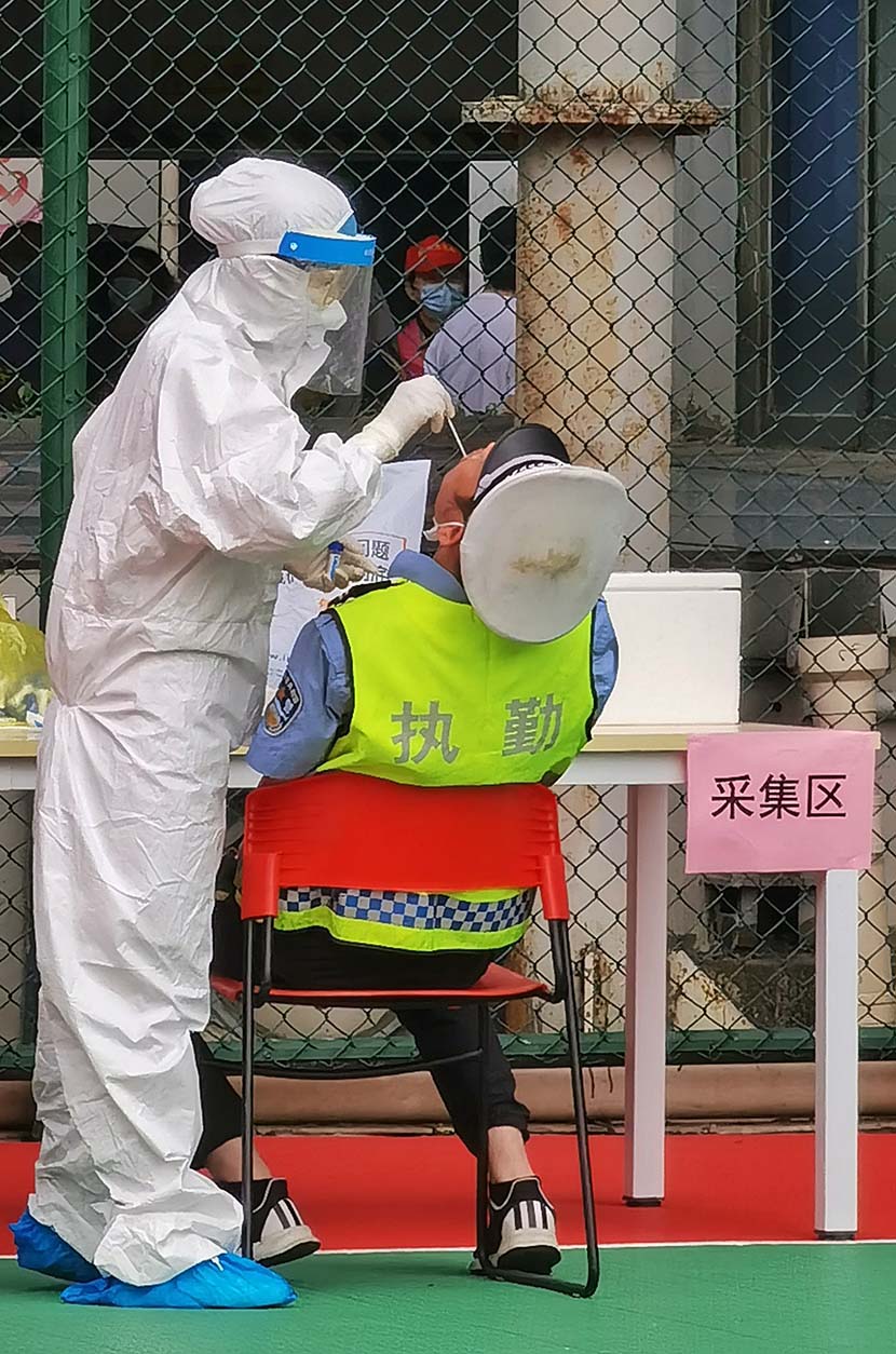A security guard receives nucleic acid testing at the roof of a shopping mall in Wuhan, Hubei province, May 15, 2020. Wuhan, the central Chinese city where the novel coronavirus was first detected, is planning to conduct full-scale nucleic acid testing of its 11 million residents over the next 10 days. People Visual