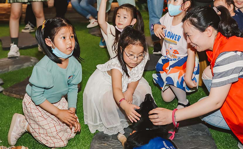 Children play with dogs during an animal-assisted therapy event at the Bund Finance Center in Shanghai, May 17, 2020. Courtesy of the Bund Finance Center