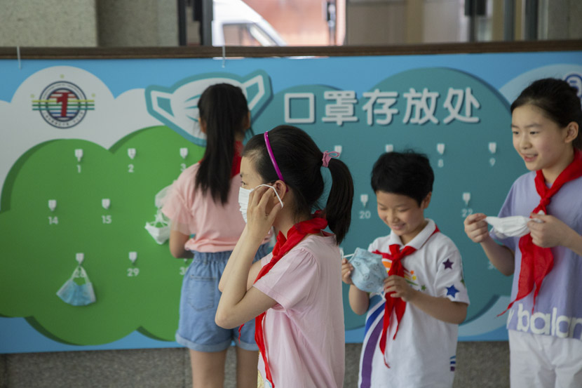 Ahead of PE class, students hang their face masks on numbered hooks at Luwan No. 1 Central Primary School in Shanghai, May 18, 2020. Primary school students were some of the last in the country to restart class after the COVID-19 pandemic. Shi Yangkun/Sixth Tone