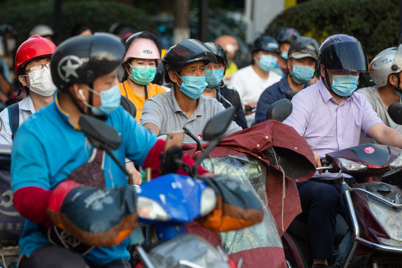 Riders don headgear in Hangzhou, Zhejiang province, May 18, 2020. In an effort to boost road safety, China unveiled a “One Belt, One Helmet” policy earlier this month, though officials were forced to partially delay implementation after helmet prices skyrocketed nationwide. Chen Zhongqiu/People Visual